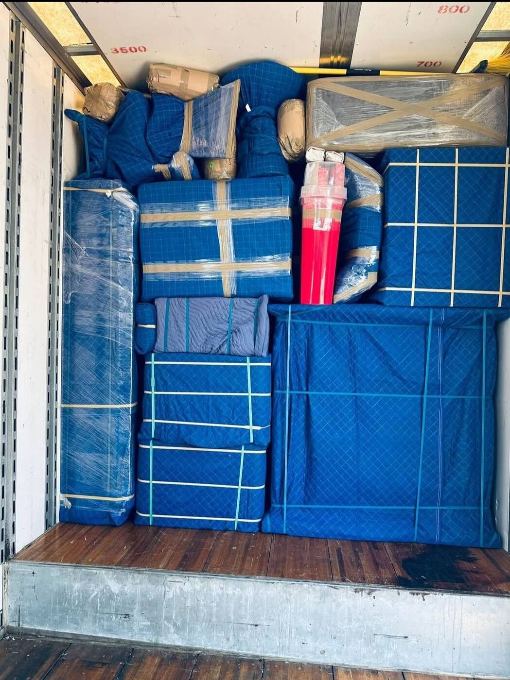 Mattresses and furniture fully covered in blue moving blankets inside truck — Carrollton, TX movers