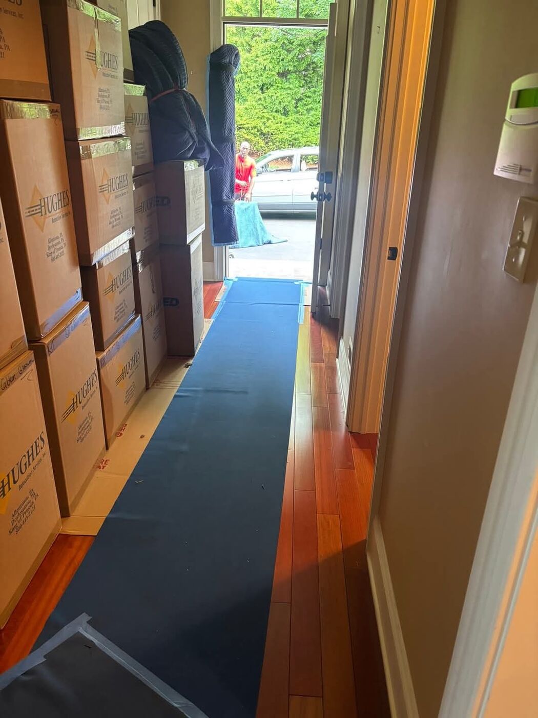 Blue floor runner protecting hardwood floors during move day in residential home hallway — One World Van Lines Southlake, TX DFW professional movers