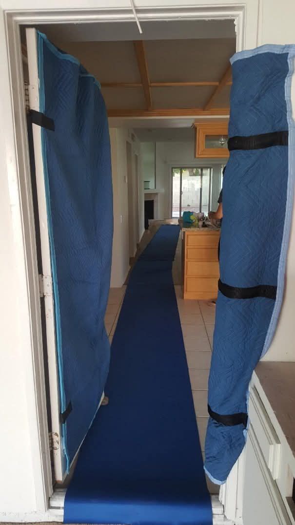 Door frame fully padded with blue moving blankets and hallway protected with blue carpet runner — One World Van Lines Euless, TX DFW Metroplex professional home protection movers