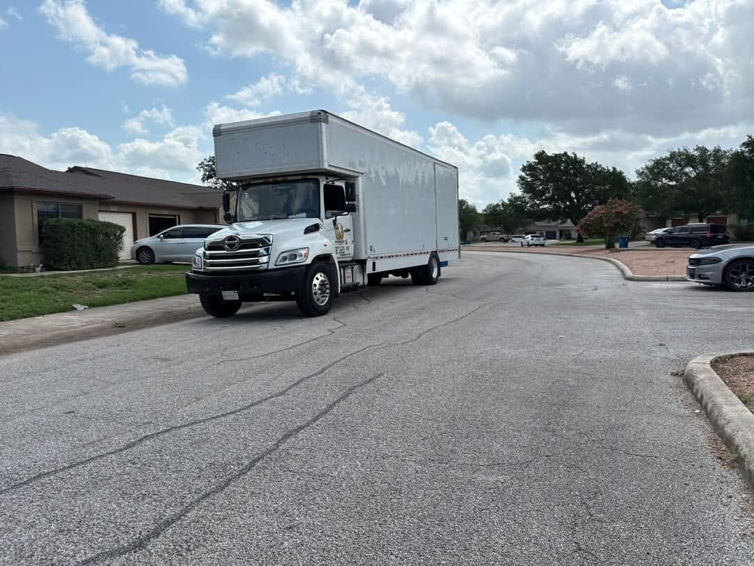 One World Van Lines white Hino box truck on residential street on location for a move — Carrollton, TX DFW Metroplex professional movers