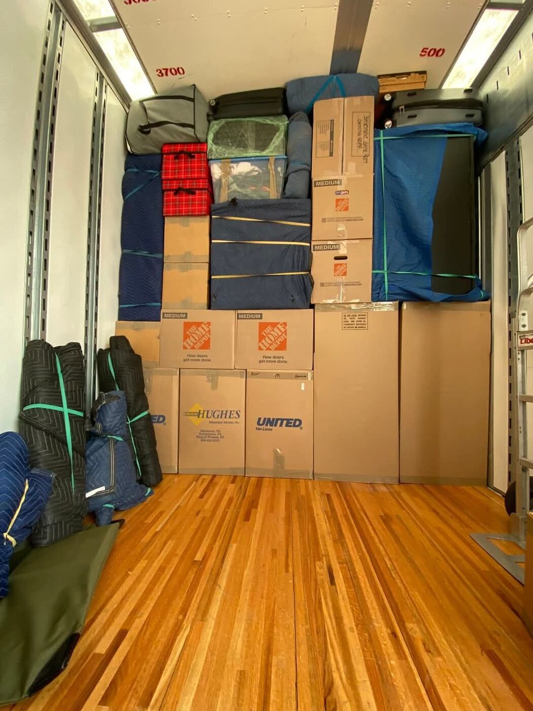 Home Depot medium boxes and blue blanket-wrapped furniture partially loaded in moving truck — One World Van Lines North Dallas, TX DFW movers
