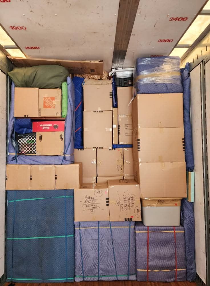 Full moving truck with Home Depot boxes, blue blanket-wrapped furniture, plastic tubs and ratchet straps — One World Van Lines Burleson, TX DFW professional movers