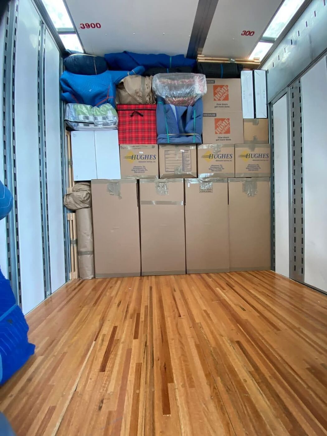 Home Depot medium boxes and tall wardrobe boxes partially loaded in moving truck — One World Van Lines Richardson, TX DFW professional movers
