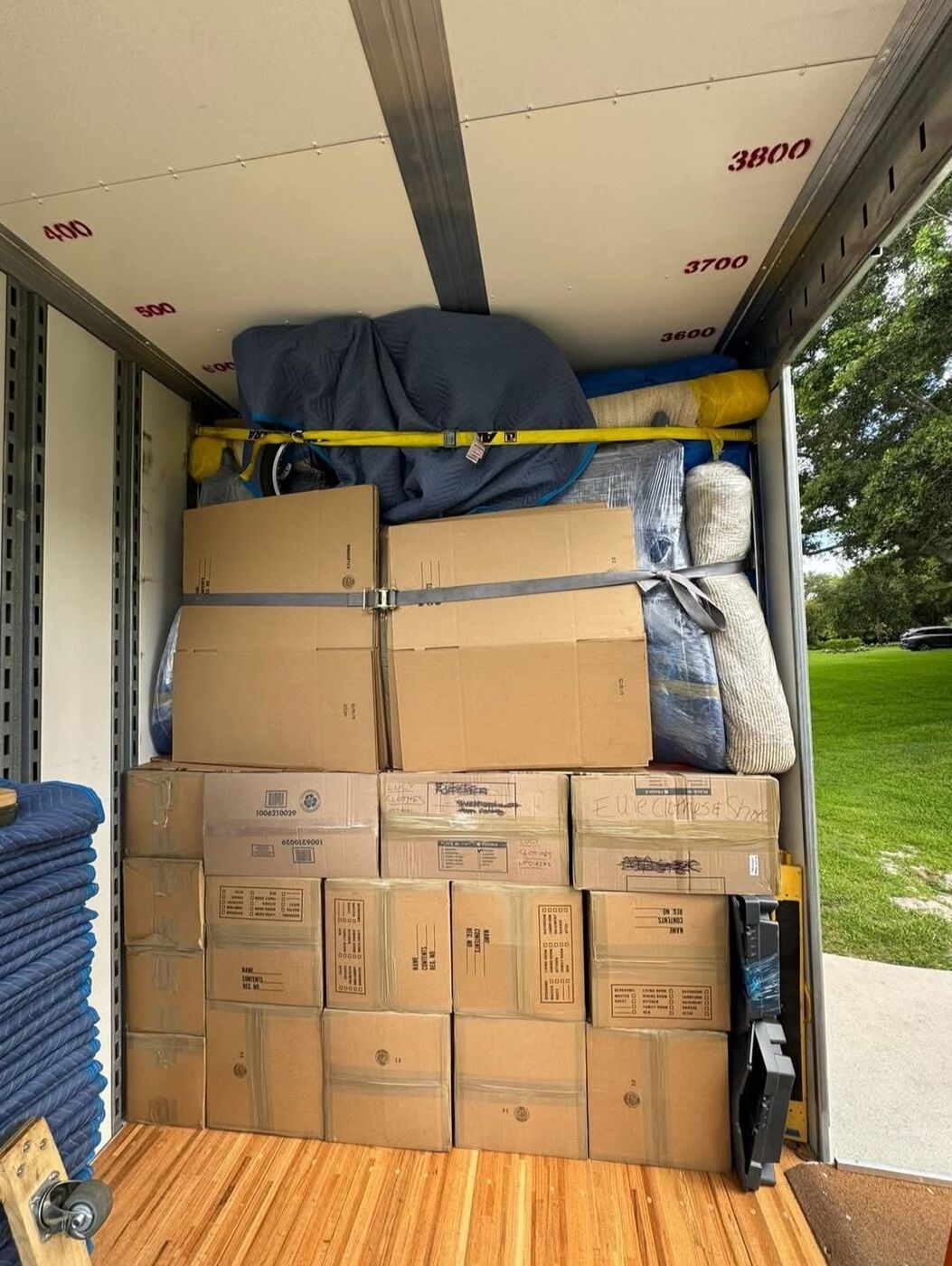 Labeled Kitchen and bedroom boxes secured with ratchet straps in moving truck — One World Van Lines Cedar Hill, TX DFW professional movers