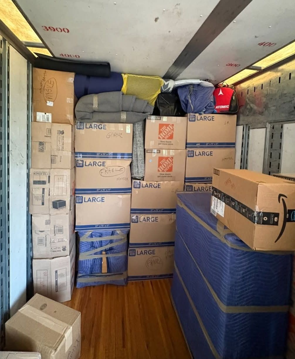 Large fragile-labeled Home Depot boxes, Amazon box and blue blanket-wrapped mattress loaded in truck — One World Van Lines Mansfield, TX DFW Metroplex