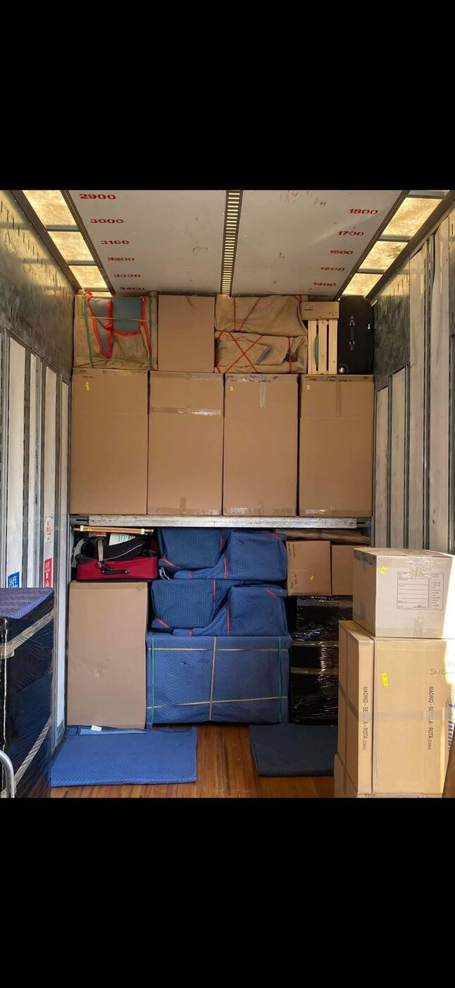Large moving boxes and blue blanket-wrapped furniture loaded in truck for long-distance move — One World Van Lines Texas