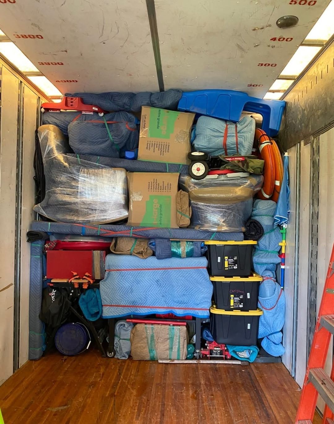 Moving truck packed to the ceiling with mixed household items, plastic storage bins, Hefty boxes, blue blankets and tools — One World Van Lines Fort Worth, TX DFW movers