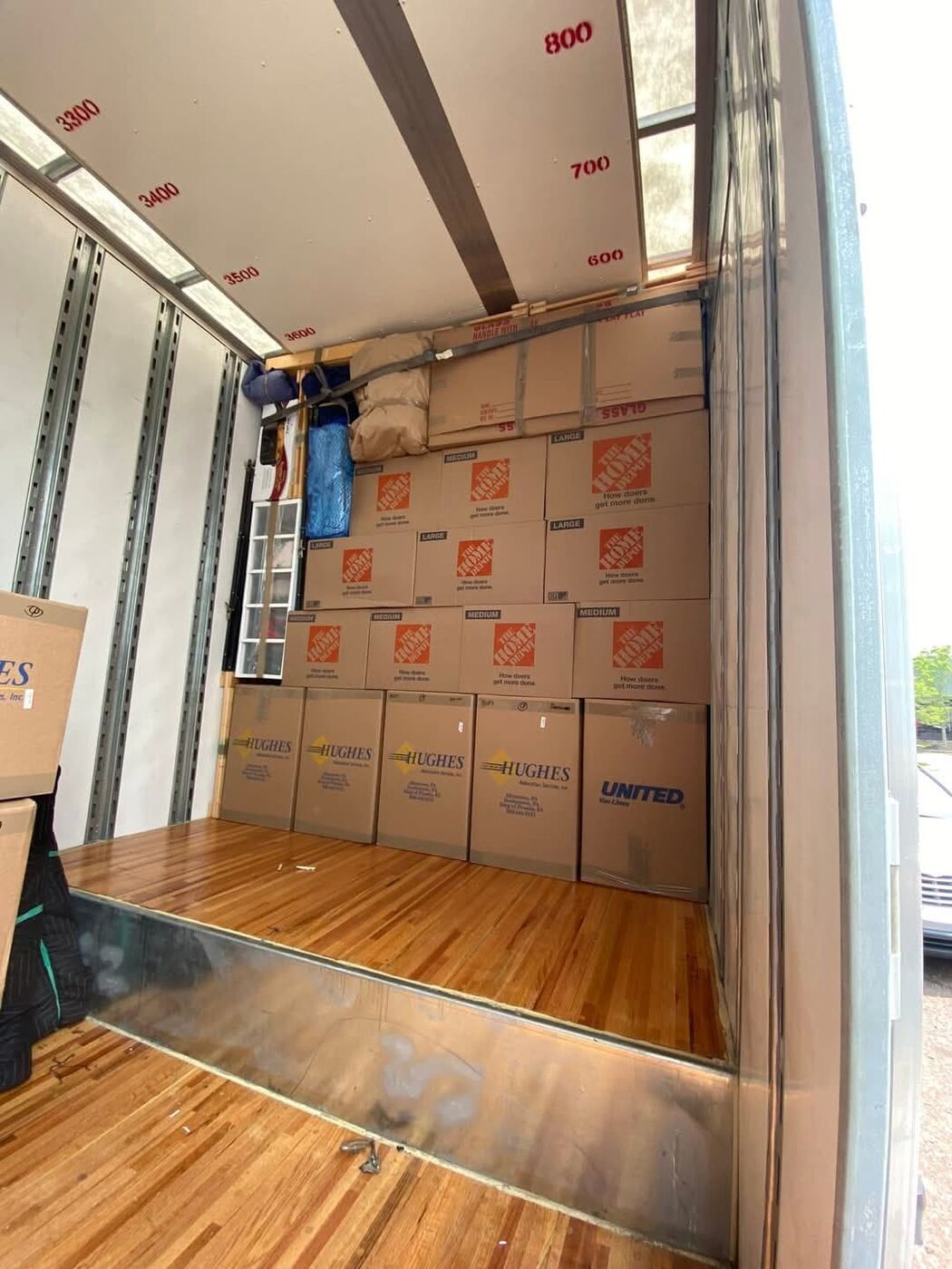Organized Home Depot large and medium boxes neatly loaded in moving truck — One World Van Lines professional movers Plano, TX DFW
