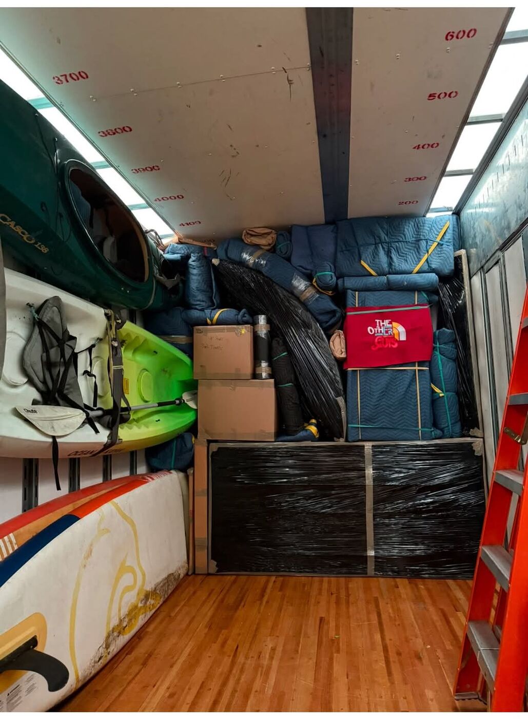 Kayaks, paddleboards, and specialty outdoor equipment secured in moving truck — One World Van Lines specialty movers DFW, TX