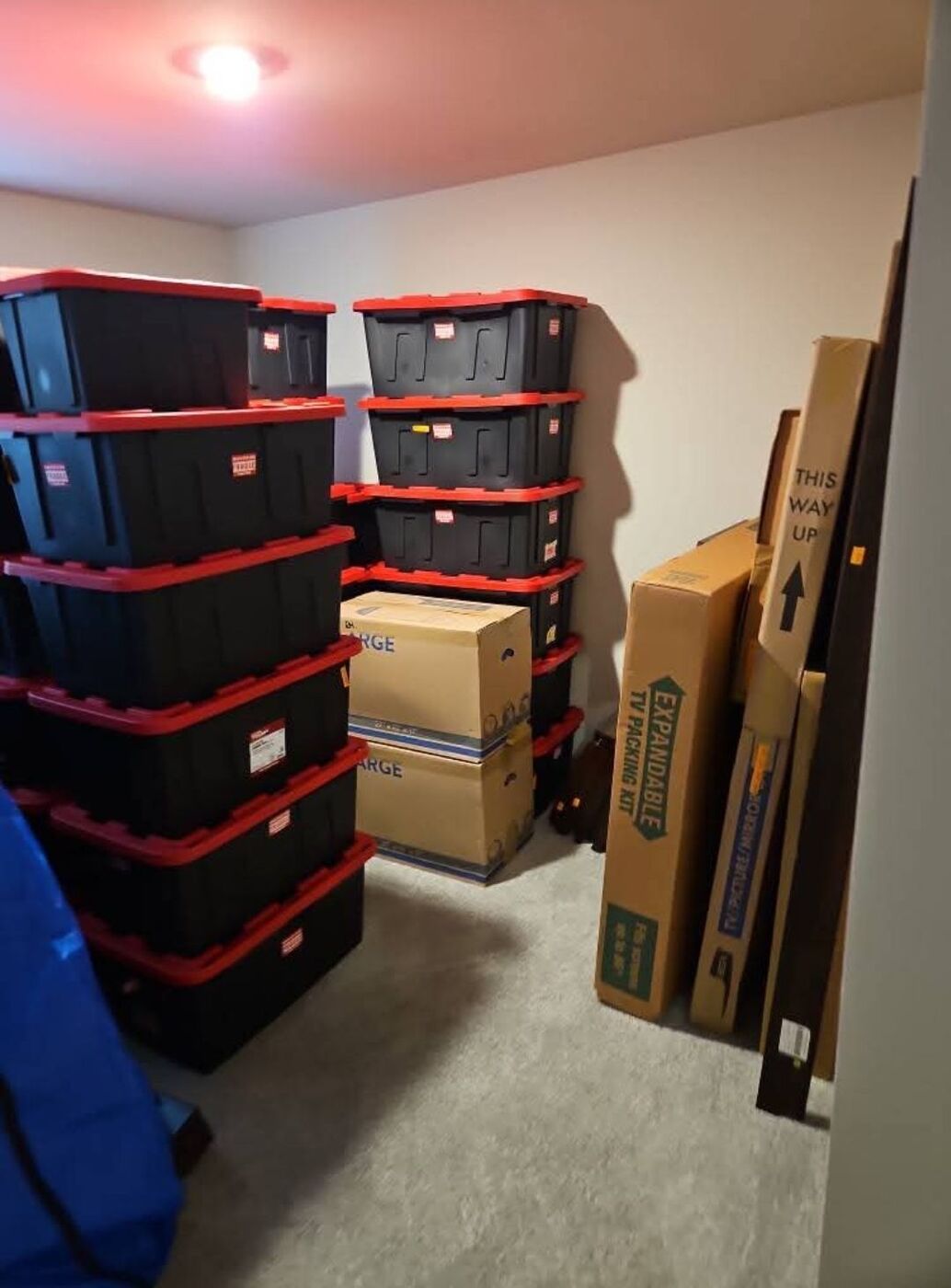 Stacked black and red Sterilite storage totes, large boxes and TV expandable packing kit organized for move — One World Van Lines Celina, TX DFW movers