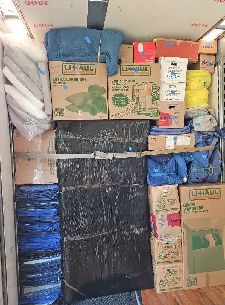 Moving truck loaded with U-Haul extra-large boxes, wardrobe boxes, plastic-wrapped flat panels and blue moving blankets — One World Van Lines Grapevine, TX DFW Metroplex movers