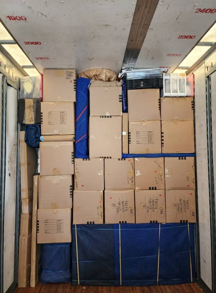 Moving truck packed wall-to-wall with hand-labeled cardboard boxes and blue blanket-padded floor — One World Van Lines Sachse, TX DFW Metroplex professional movers