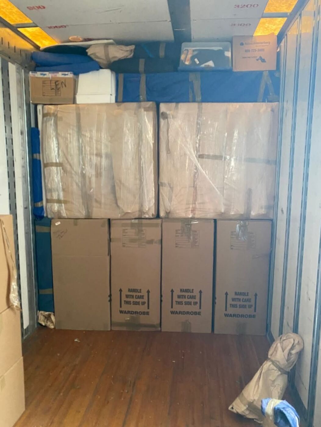 Wardrobe Handle-With-Care boxes and plastic-wrapped flat items loaded in moving truck — One World Van Lines Waxahachie, TX DFW area movers