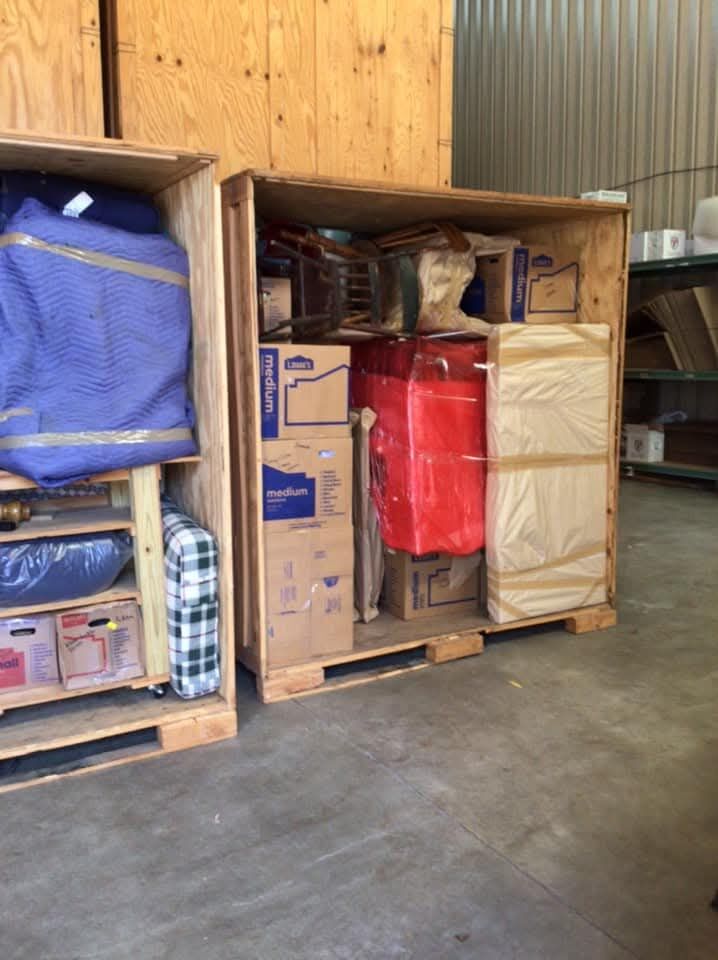 Wooden storage vault crate packed with household goods, boxes, and moving blankets — One World Van Lines storage Carrollton, TX