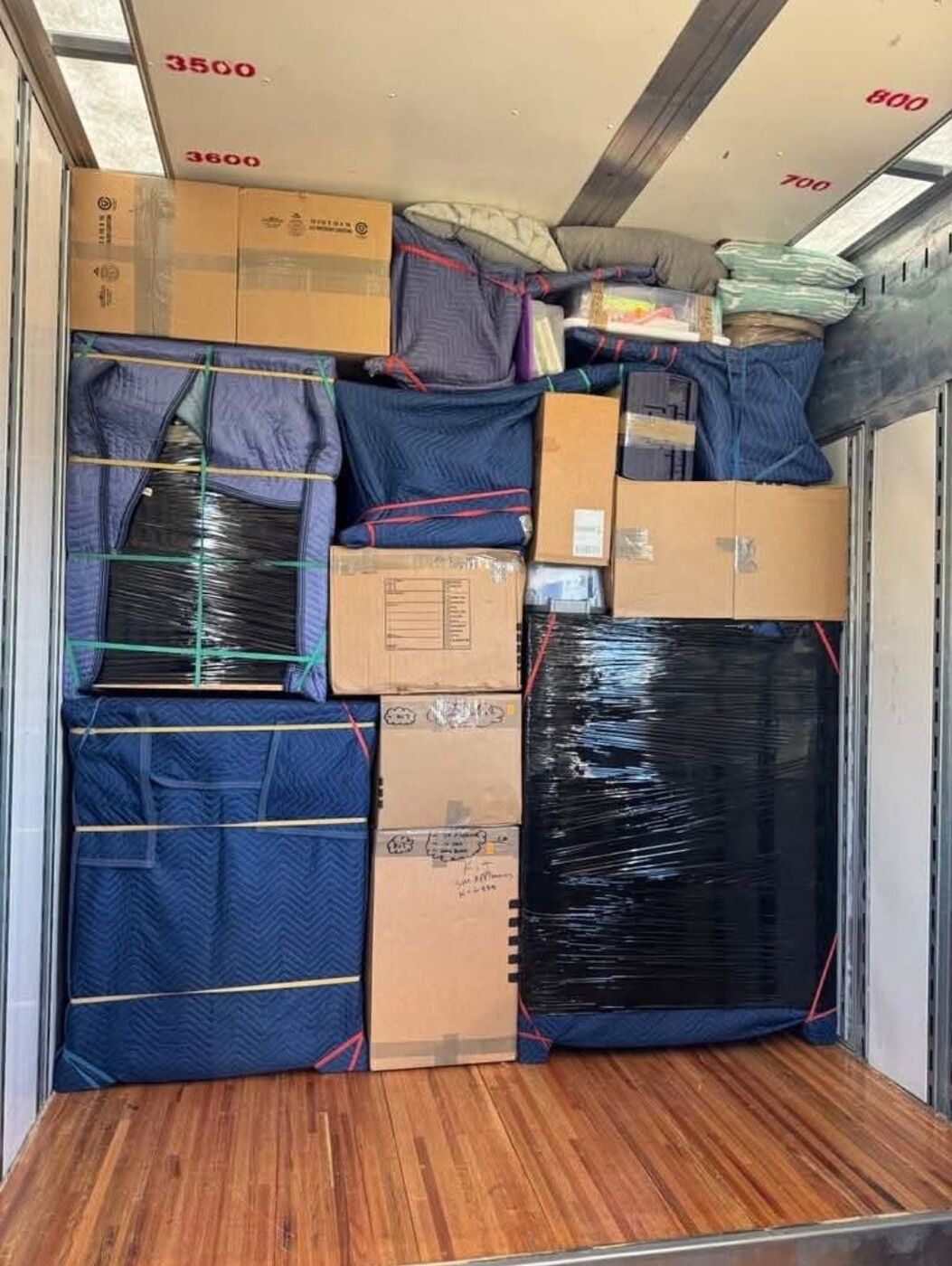Organized truck loading with mixed household items, blue blankets, and boxes — Texas moving company