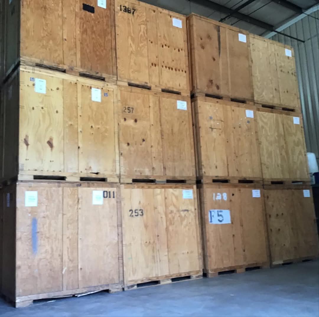Stacked wooden storage vaults labeled for customers — DFW moving company Carrollton